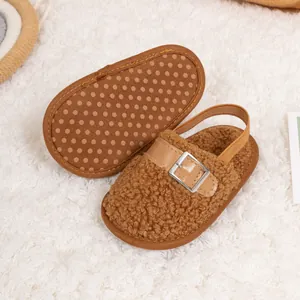 Detail of baby plush slipper featuring anti-slip sole and adjustable leather buckle strap