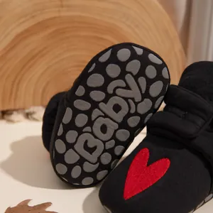 Detail der rutschfesten Sohle mit Baby-Aufdruck an gestreiften Lauflernschuhen