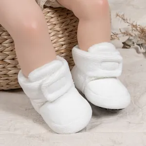 Close-up of white baby winter boots with corduroy texture and warm fleece lining