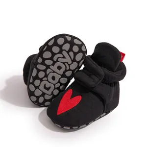 Detailansicht der Babyschuhe mit rutschfesten Noppen und rotem Herz-Aufnäher