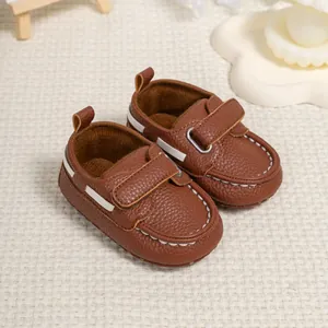 Macro detail of brown leather baby moccasins with velcro strap and white stitching
