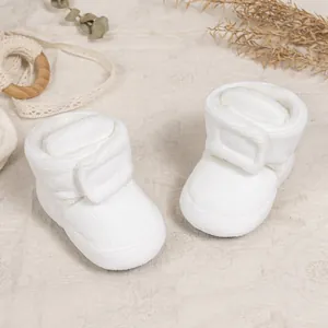 Detail of warm white corduroy baby boots with fleece lining and velcro closure