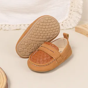 Detail of baby brown loafers showing non-slip rubber sole size 18 and woven PU texture