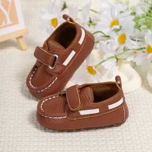 Close-up of brown baby walking shoes with white stitching and velcro straps