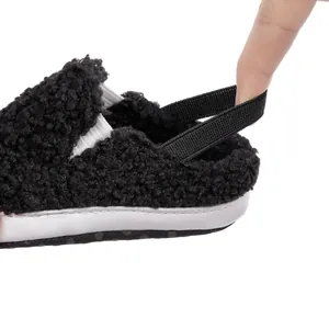 Close-up of flexible elastic heel strap on black plush baby walking shoes for toddlers