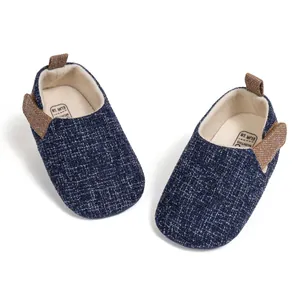 Detail of baby walking shoes showing breathable navy tweed fabric and soft inner lining