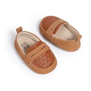 Detail of baby loafer in brown faux leather with decorative stitching and soft inner sole