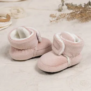 Close-up of pink corduroy baby boots with warm fleece lining and velcro closure