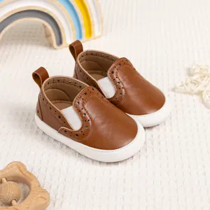 Scarpe primi passi neonato in pelle marrone con decori brogue ed elastici bianchi