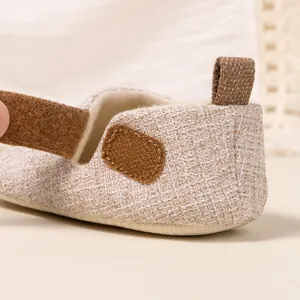 Detail of baby walking shoe showing woven texture, soft fleece lining and brown velcro strap