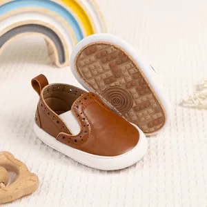 Dettaglio di scarpine per neonati con suole in gomma antiscivolo e design brogue