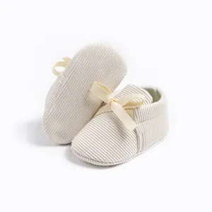 Detail of baby corduroy shoes in beige with soft ribbon bow and non-slip fabric sole