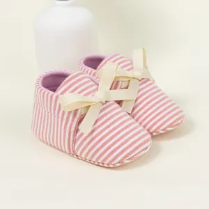 Infant striped walking shoes with a cream bow and soft pink fabric for baby girls
