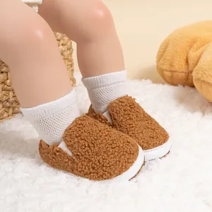 Close-up of cozy brown fleece baby walking shoes with soft white soles on a model