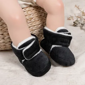 Detail of warm black corduroy baby boots with soft plush lining and side velcro closure