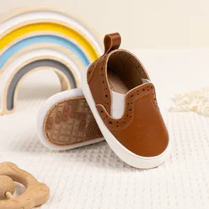 Scarpe neonato in pelle marrone caramello con dettagli brogue e suole in gomma bianca