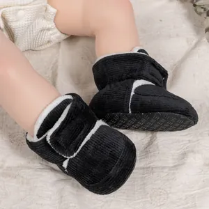 Detailed view of black corduroy baby winter boots with thick white faux fur lining