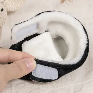 Detail of warm lamb wool lining and adjustable velcro strap on black corduroy baby boots