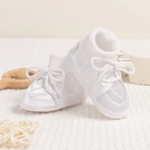 Detail of white lace baby baptism shoes with soft soles and knit ankle socks