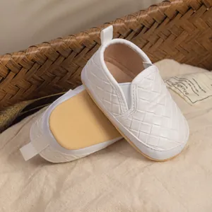 Close-up of white infant slip-on shoes with textured weaving and soft anti-slip soles