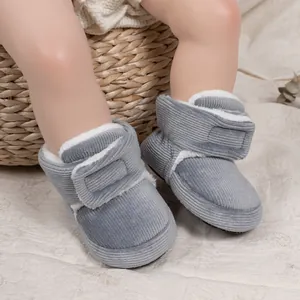 Close-up of baby winter boots with grey corduroy fabric and warm white plush lining