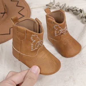 Vue détaillée de bottes de cow-boy pour bébé avec broderie blanche et fermeture éclair