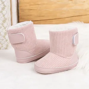 Detail der rosa Baby-Schneestiefel mit weichem Futter und Klettverschluss auf Plüschteppich