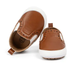 Dettaglio di scarpe primi passi marroni con decorazioni brogue e suole antiscivolo