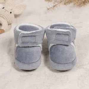 Detail of grey corduroy baby boots with warm faux fur lining and velcro strap closure