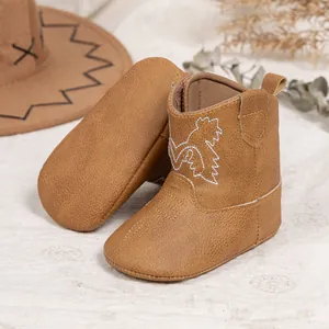 Détail de bottes cowboy pour bébé marron avec broderie et chapeau assorti