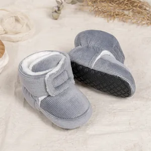 Close-up of gray corduroy baby winter boots with soft non-slip soles and warm faux fur