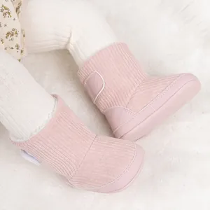Detail von warmen rosa Strick-Babyschuhen mit Klettverschluss und weicher Sohle für Winter