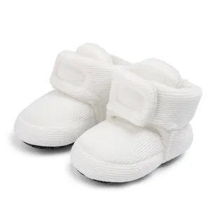 Detailed view of white corduroy baby winter boots with adjustable velcro strap closure