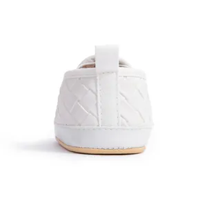 Detail view of baby walker shoes showing woven white texture and soft brown sole heel