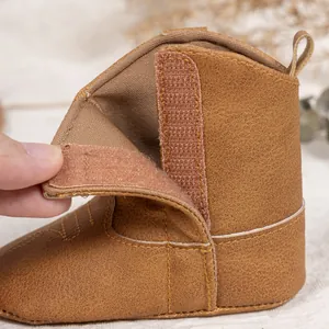 Gros plan de bottes de cowboy pour bébé marron avec velcro et doublure douce