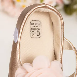 Détail de chaussure bébé champagne avec fleur rose et marquage de taille EUR 18