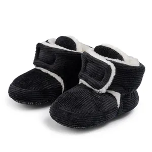 Close-up of black corduroy baby boots with white fleece lining and Velcro closure