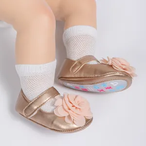 Vue détaillée de chaussures bébé Mary Jane or rose avec une grande fleur en tissu rose