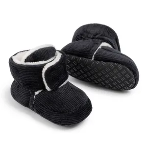 Detail of warm black corduroy baby boots with faux fur lining and non-slip sole