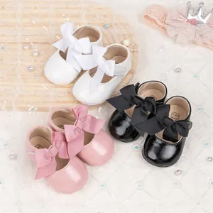 Flat lay of baby girl Mary Jane shoes in white, pink, and black with large bow details