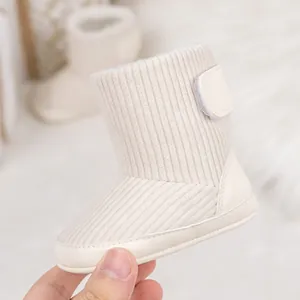 Detail eines warmen cremeweißen Babystiefels mit weichem Fleecefutter und Klettverschluss