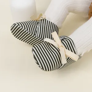 Detail view of baby striped loafers with soft soles and decorative ribbon bow