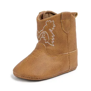 Détail de bottes de cowboy pour bébé marron avec broderie blanche et coutures jaunes