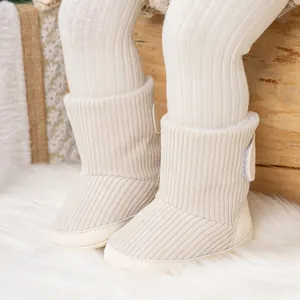 Nahaufnahme beiger Cord-Babystiefel mit weicher rutschfester Sohle und runder Schnalle