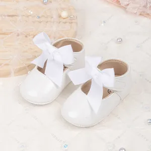White glossy patent leather baby princess shoes with large bow and velcro strap