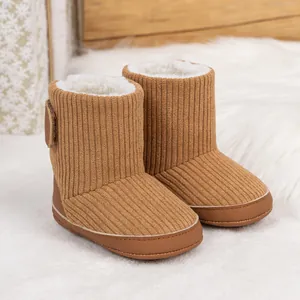 Detail von warmen braunen Cord-Babystiefeln mit dickem weißem Fleecefutter für den Winter