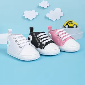 Détails de chaussures en toile pour bébés en blanc, noir et rose avec semelles souples