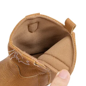 Détail de bottes de cowboy marron montrant la doublure douce et les broderies blanches