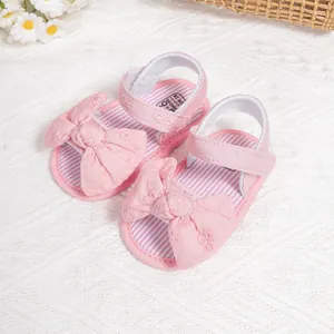 Pink baby girl sandals with large bows and adjustable velcro straps for toddlers