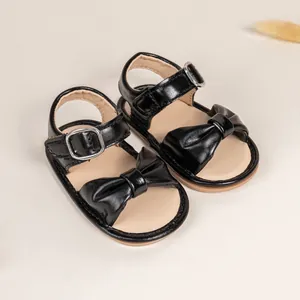 Black infant sandals with bow detail and soft anti-slip rubber sole for walking
